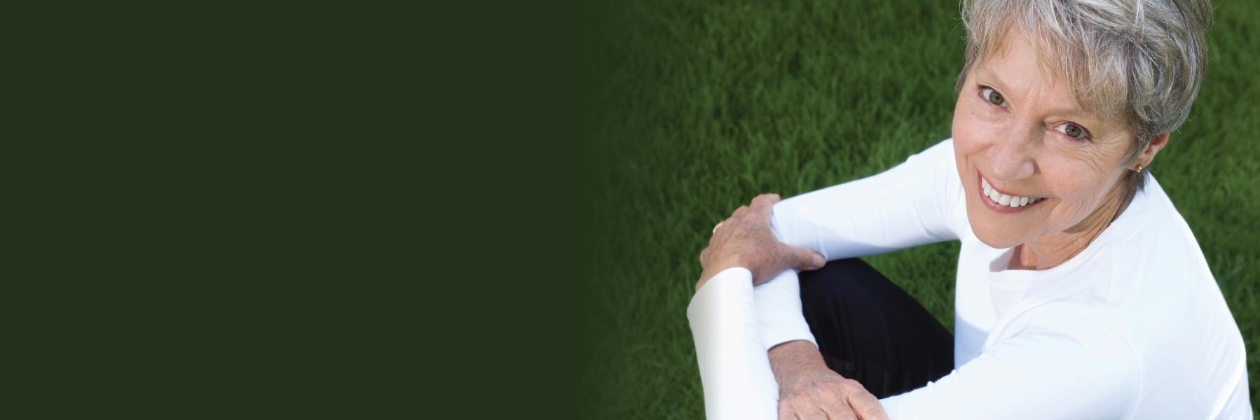 Woman sitting in the grass | Preventive Dentistry Bangor ME